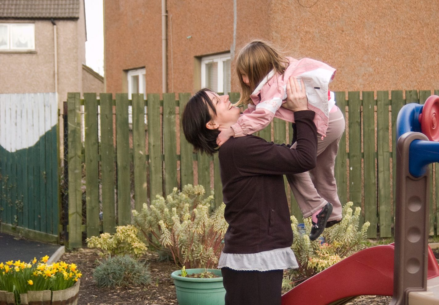 Woman lifting a little girl into the air