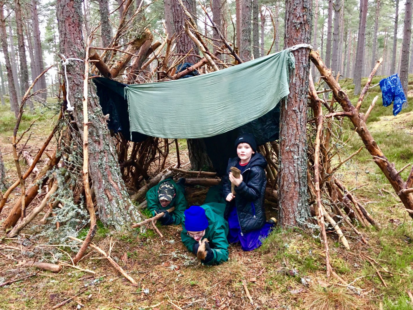 Young people with disabilities building a den in the woods