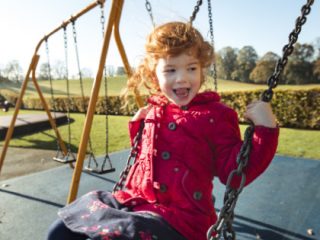 Girl playing on play park swing