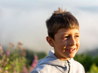 Young boy next to flowers