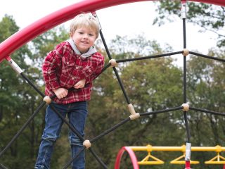 Boy on play park equipment