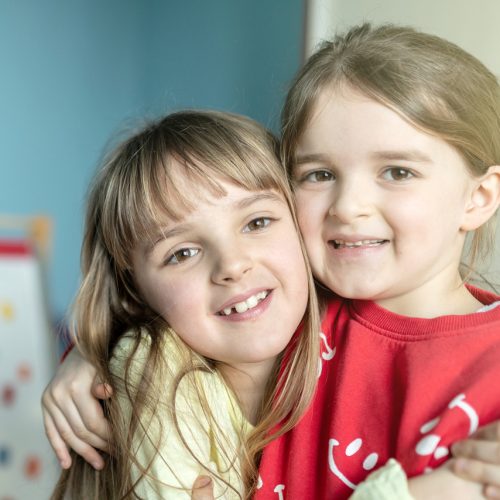 Abbie and Maya hugging in room